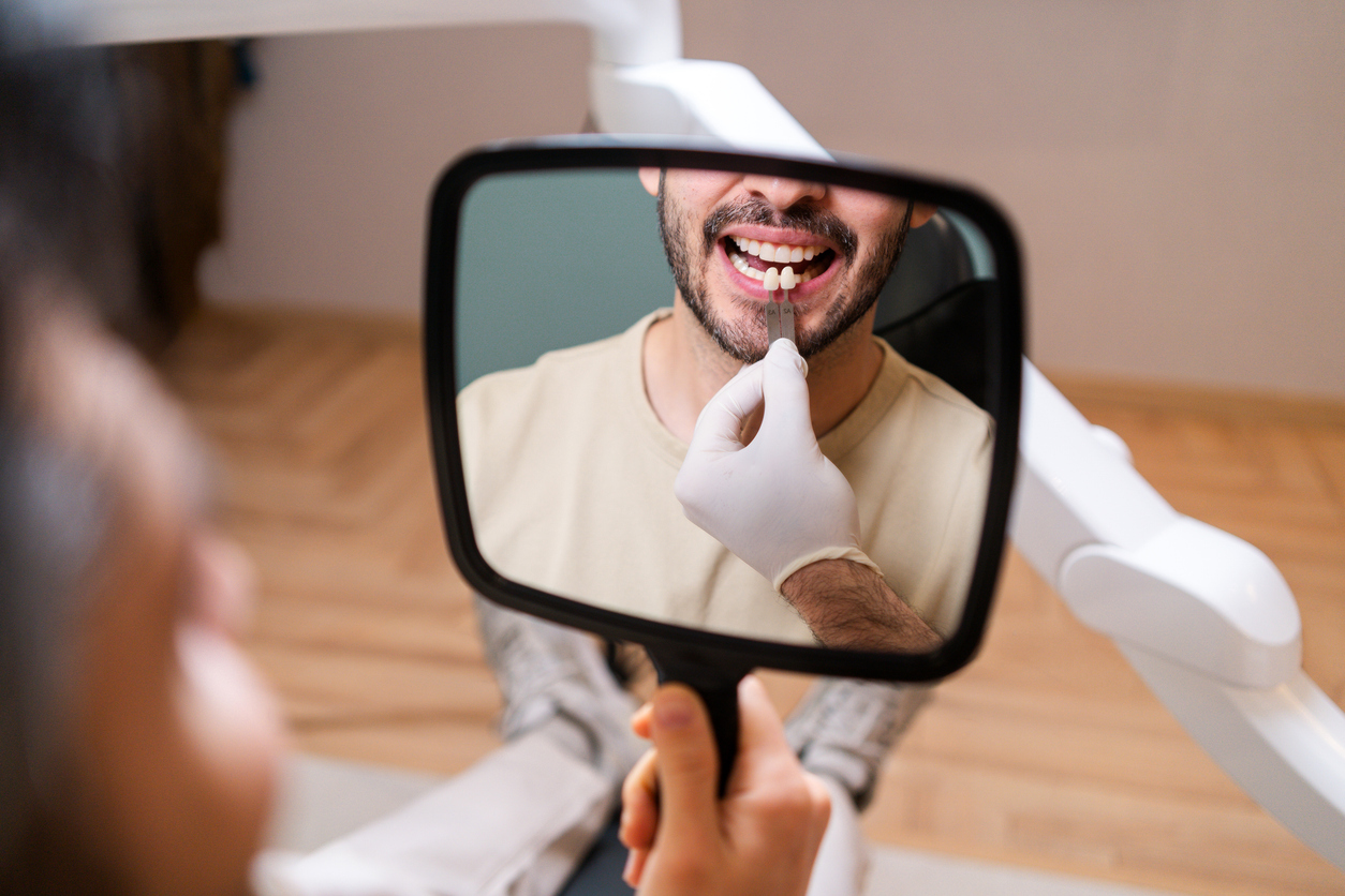 Veneers and composite bonding at Portlethen Dental Care – dentist matching tooth shade in a mirror